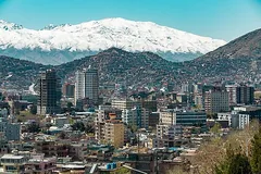Kabul city buildings below snow-covered mountains, Afghanistan
